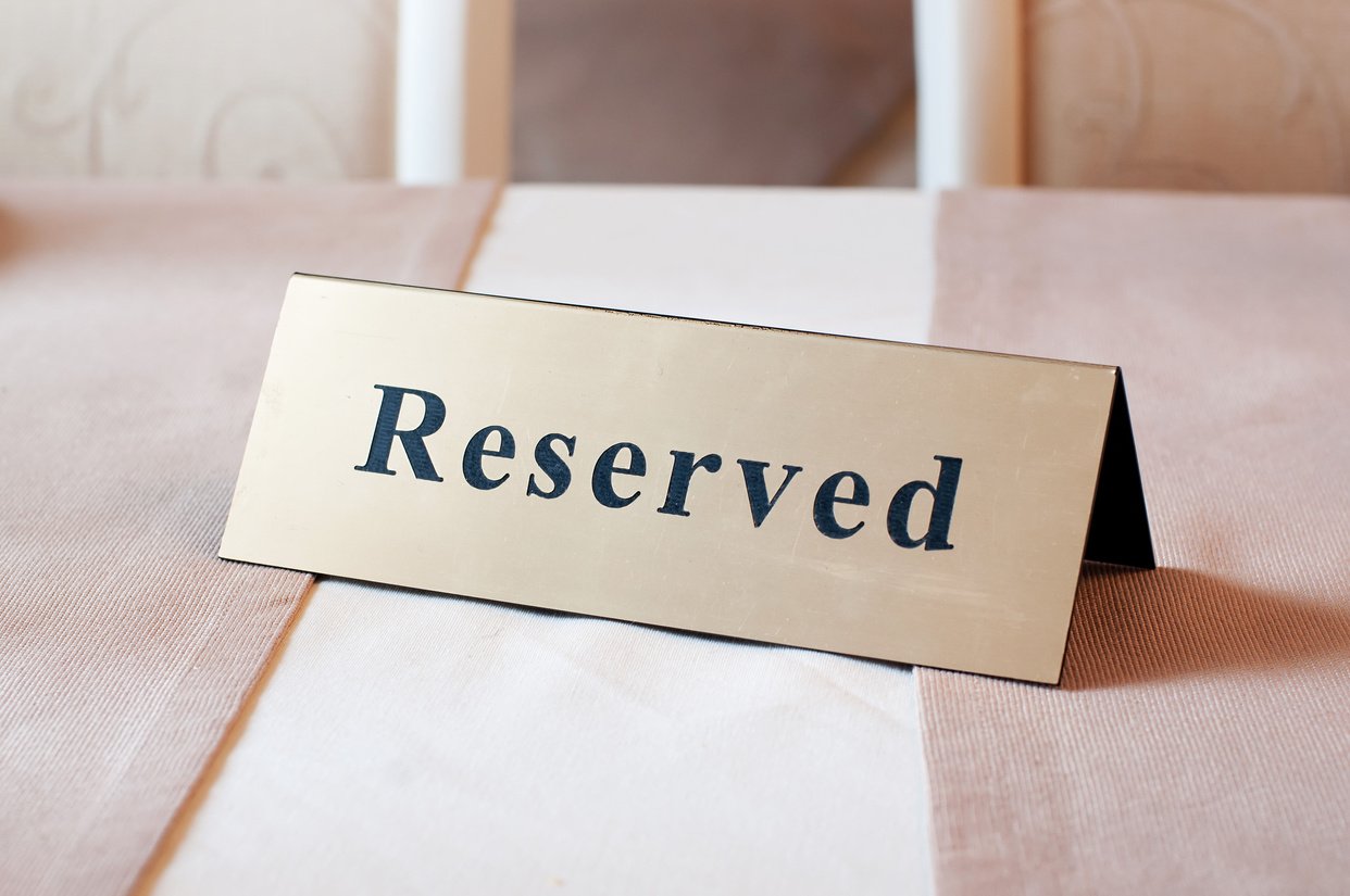 Reserved sign, reservation. On the table. Beige